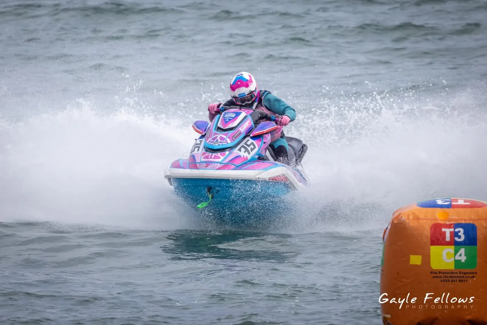 Pink and blue Yamaha #35 race sticker kit powering through spray