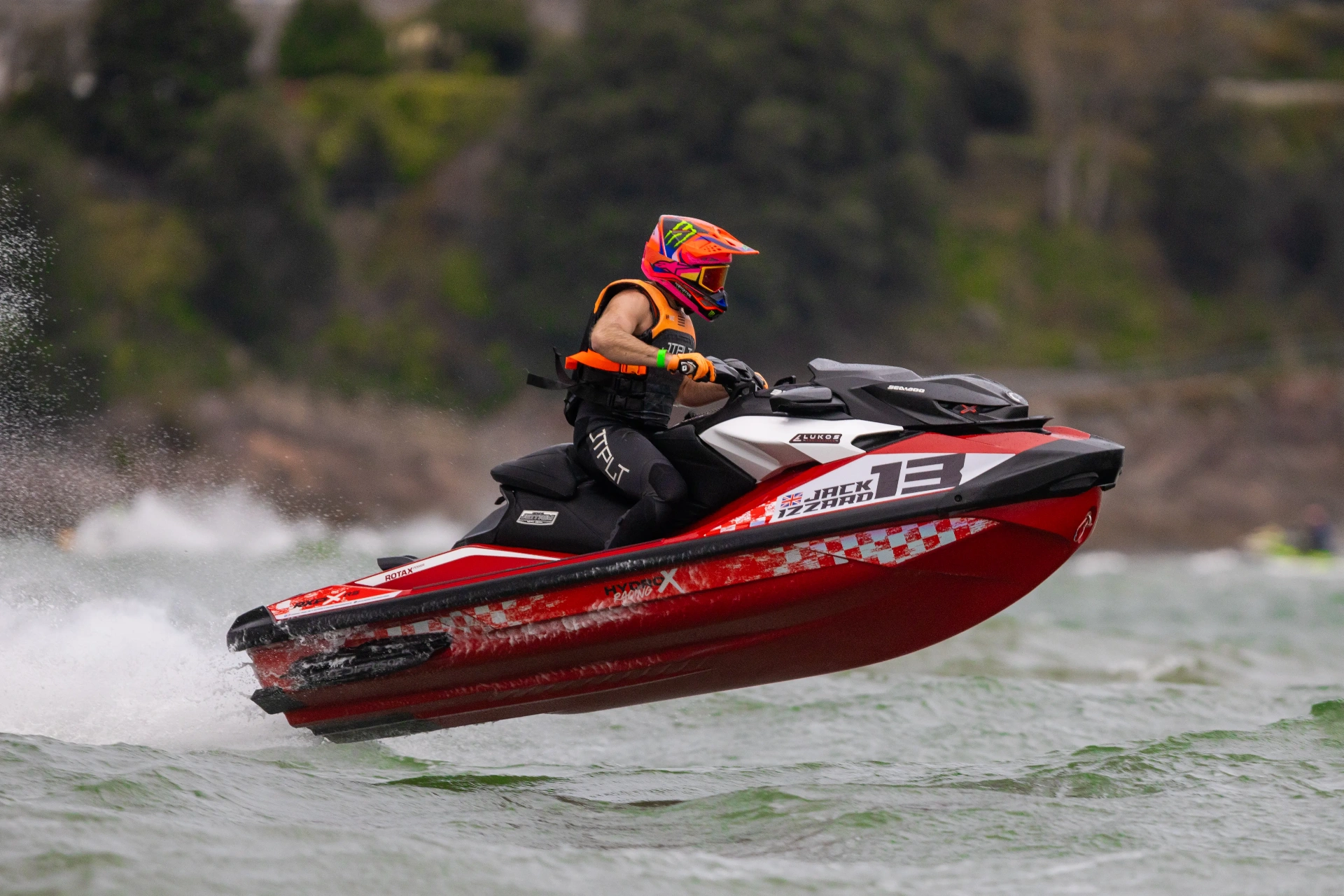 Red and black race jetski with a custom S3R Designs sticker kit carving through the swell